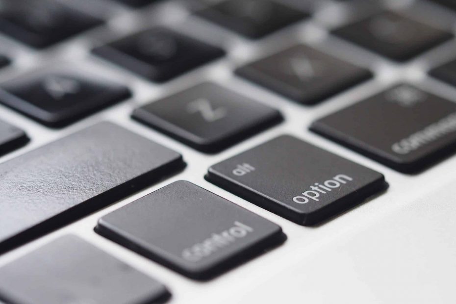 closeup of Mac keyboard with black keys focused on Option key
